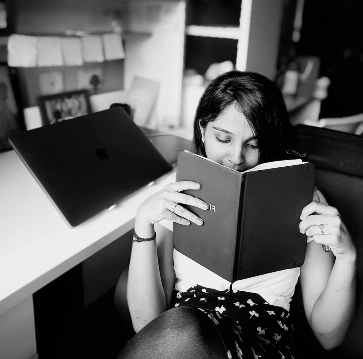 Anusha reading a notebook at her desk